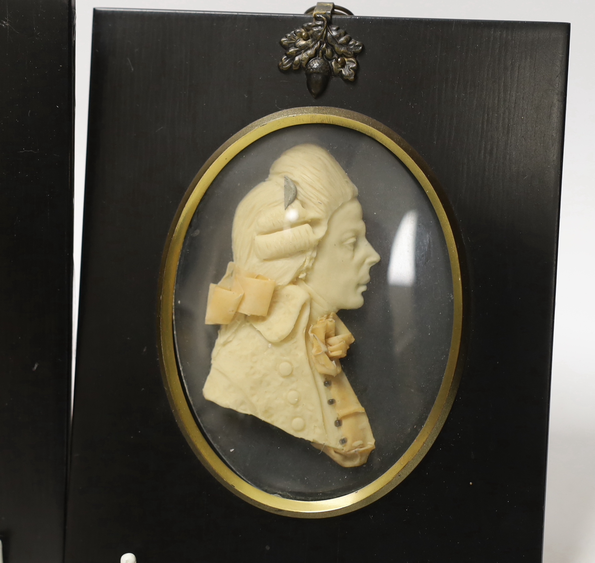 Attributed to Leslie Ray, pair of 20th century wax relief portraits of a lady and gentleman wearing 18th century dress, 15cm high including the frame